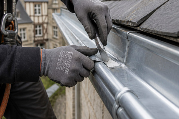 Pose et ajustement de gouttières en zinc de haute précision