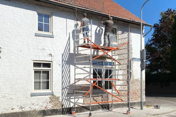 Ouvriers sur échafaudage réalisant la mise en peinture et la rénovation d'une façade